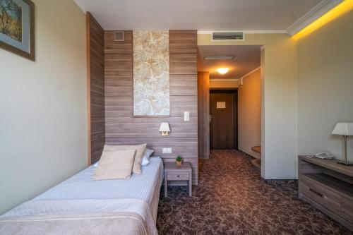 a hotel room with a bed and a television at Korona Hotel in Ostrołęka