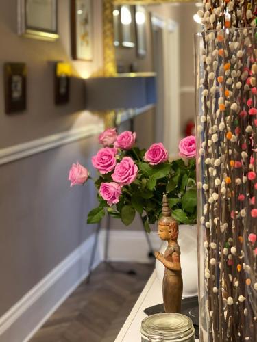 a vase with pink roses on a table at The Westbank in Torquay