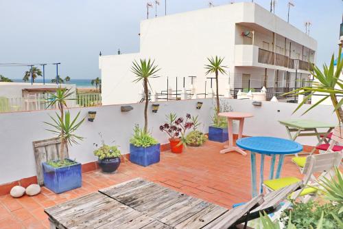 patio ze stołem, krzesłami i roślinami w obiekcie Habitación Cañaveral Playa Conil III w mieście Conil de la Frontera
