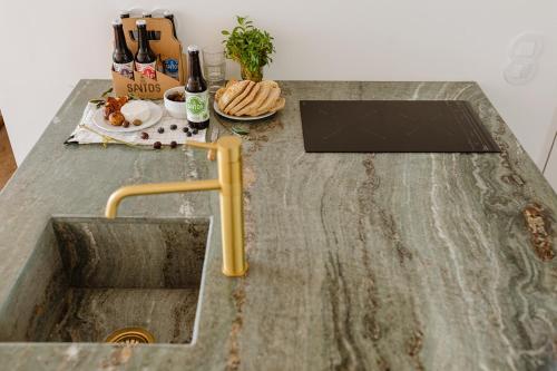 a kitchen counter with a sink and a plate of food at THE MODERNIST, Architecture experience in Faro