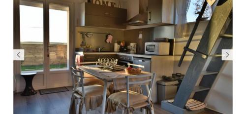 eine Küche mit einem Tisch und einigen Stühlen in der Unterkunft GITE LES AILES DU VENT- BUIGNY ST MACLOU in Buigny-Saint-Maclou
