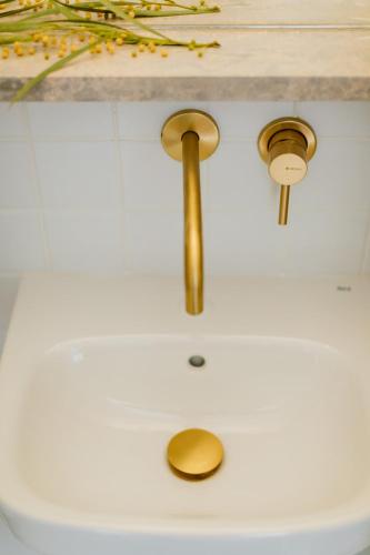 a bathroom sink with a gold faucet at THE MODERNIST, Architecture experience in Faro