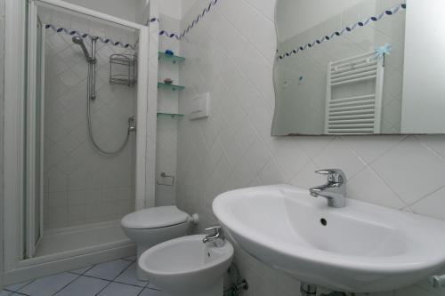 a white bathroom with a sink and a toilet at N043 - Numana, bilocale con giardino in Sirolo