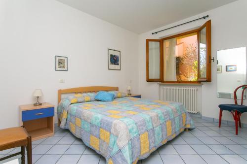 a bedroom with a bed and a table and a window at N043 - Numana, bilocale con giardino in Sirolo