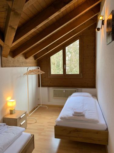 a bedroom with two beds and a lamp in it at Breathtaking Waterfall Apartment nr 3 in Lauterbrunnen