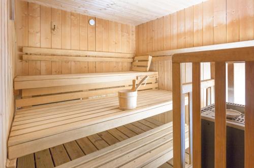 a wooden sauna with a bucket in it at Hôtel Club mmv Le Val Cenis *** in Lanslebourg-Mont-Cenis