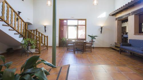 a living room with stairs and a table and chairs at Casa Rural Pilón del Fraile in Oropesa