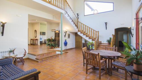 a living room with a table and chairs and stairs at Casa Rural Pilón del Fraile in Oropesa
