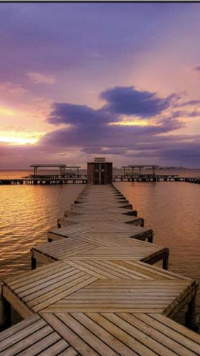 a wooden pier in the water at sunset at Hotel Madrid in Santiago de la Ribera