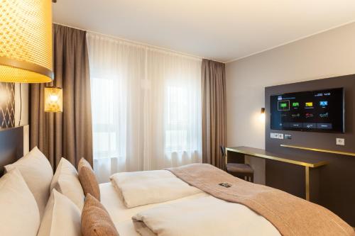 um quarto de hotel com uma cama e uma televisão de ecrã plano em the niu Mesh - Apartments em Stuttgart