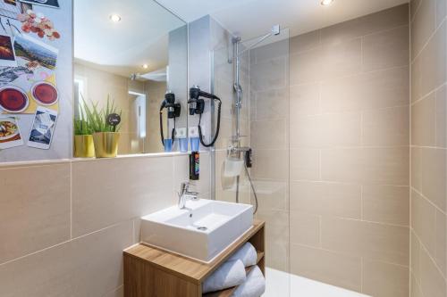 uma casa de banho com um lavatório e um chuveiro em the niu Mesh - Apartments em Stuttgart