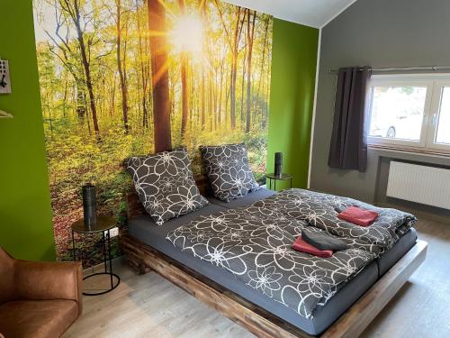 um quarto com uma cama com uma fotografia de uma floresta em Haus Wunschlos Auf Aderich em Monschau