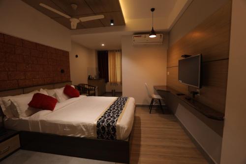 a bedroom with a bed and a flat screen tv at Bhavanam Regency Guruvayoor in Guruvāyūr