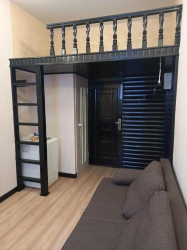 a room with a loft bed with a couch at Apartament Park3 in Odesa