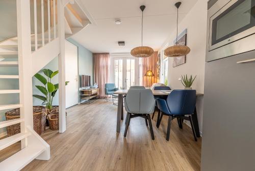 a dining room and living room with a table and chairs at Boutique Resort Schaardijk vakantiewoning in Scharendijke