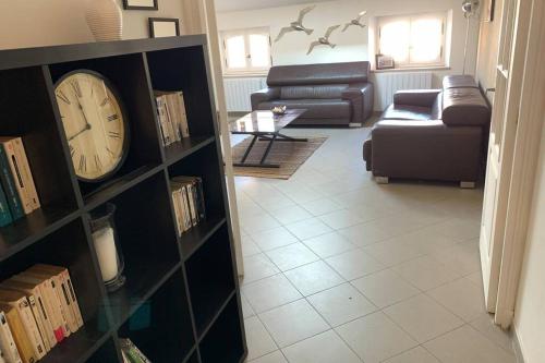 a living room with a clock on a book shelf at Bel appartement 4 étoiles Centre Historique Toulon in Toulon