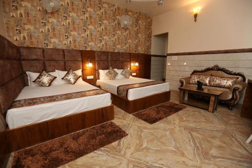 Habitación de hotel con 2 camas y sofá en The Park View Hotel en Amritsar