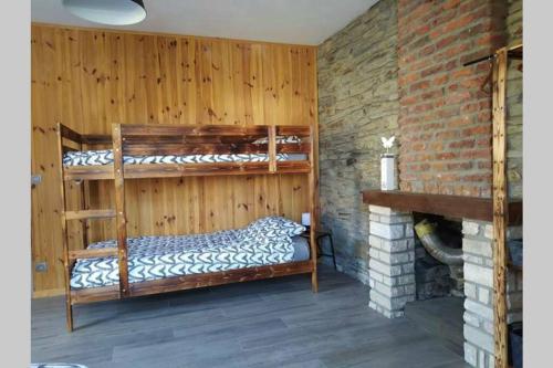 a room with two bunk beds and a fireplace at Le repaire Ardennais in Rossart
