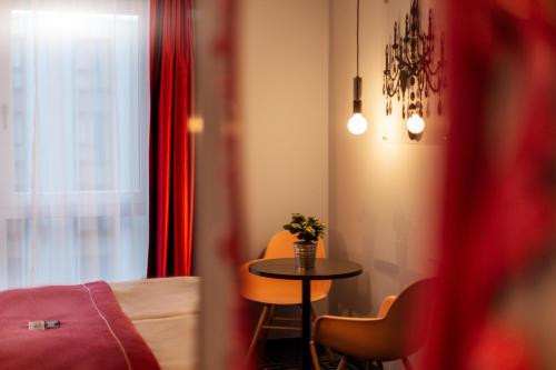 a room with a table and chairs and a window at the niu Mood - Apartments in Mainz