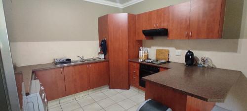 a kitchen with wooden cabinets and a counter top at Kingfisher 15 - Home away from home in Margate