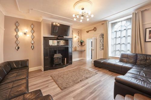 a living room with a leather couch and a fireplace at Host & Stay - Rosedale House in Richmond