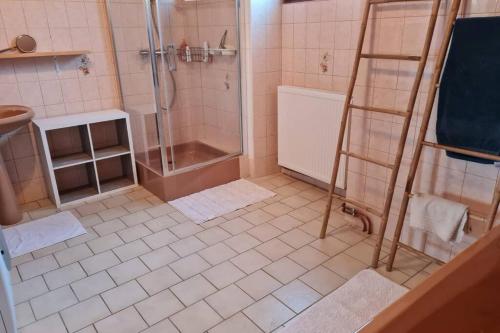 La salle de bains est pourvue d'une douche et de carrelage. dans l'établissement L'Armance - Magnifique Maison typique morvan avec piscine, à Nuars