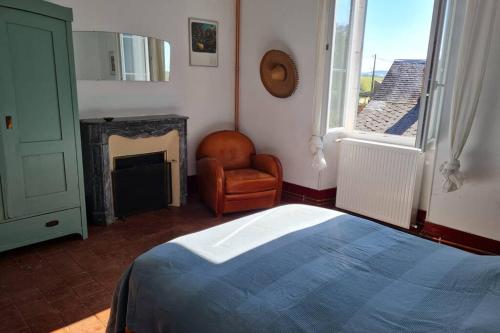 - une chambre avec un lit, une chaise et une cheminée dans l'établissement L'Armance - Magnifique Maison typique morvan avec piscine, à Nuars
