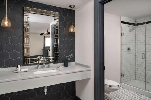uma casa de banho com um lavatório, um WC e um espelho. em Hotel Morgan a Wyndham Hotel em Morgantown