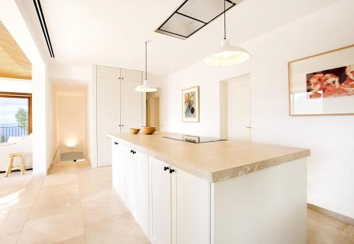 a kitchen with white cabinets and a counter top at Sa Casa des Mirador in Fornalutx
