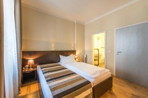 een slaapkamer met een groot bed met een houten hoofdeinde bij Altstadt Hotel & Café Koblenz in Koblenz