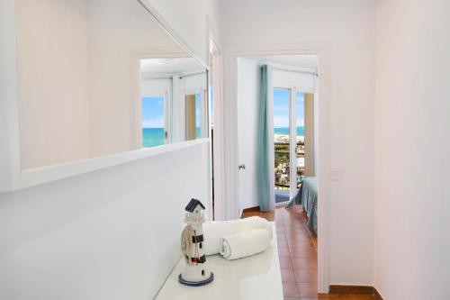 Santa Susanna Sunrise Apartment في سانتا سوزانا: حمام أبيض مع مرآة وإطلالة على المحيط