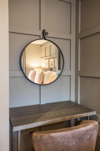 a mirror on a table with a chair in a room at No1 Apartments & Bedrooms St Andrews - St Mary's in St. Andrews