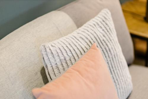 an orange pillow sitting on a couch with a pillow at No1 Apartments & Bedrooms St Andrews - St Mary's in St. Andrews