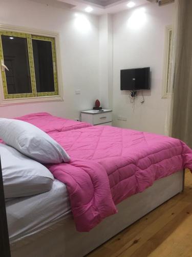 a pink blanket on a bed in a bedroom at Ramco For Furnished Apartments And Accommodation Compound Leila in Cairo