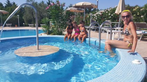a group of girls sitting in a swimming pool at Agriturismo I Tesori del Sud Vieste, Puglia in Vieste