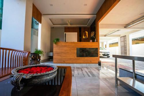 a living room with a bowl filled with red roses at Sarvam Serviced Apartment in Coimbatore