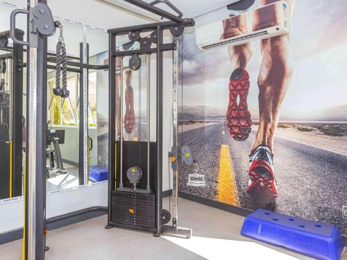 a gym with a mural of a man with his foot in shoes at Mercure Sao Paulo Vila Olimpia in São Paulo