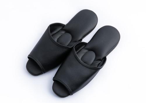 a pair of black flip flops on a white background at APA Hotel & Resort Tokyo Bay Makuhari in Chiba