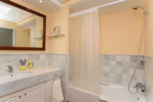y baño con lavabo, ducha y espejo. en Villa Samar, en Santanyí