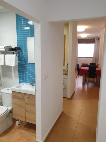 y baño con lavabo, aseo y mesa. en Apartamentos Marina Playa de Torrevieja, en Torrevieja