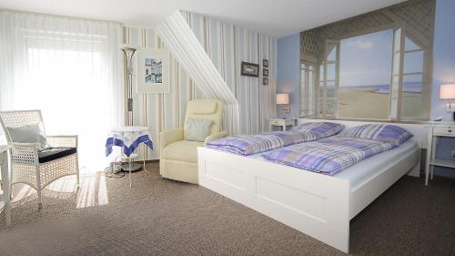 1 dormitorio blanco con 1 cama y 1 silla en Pension Leuchtfeuer, en Norden