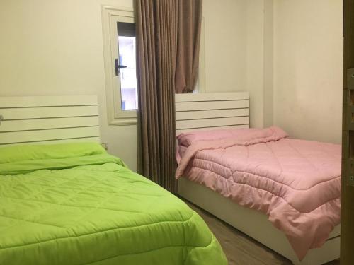 two beds sitting next to each other in a bedroom at Ramco For Furnished Apartments And Accommodation Compound Leila in Cairo