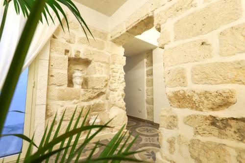 a room with a stone wall with a statue on the wall at 7Palazzi in Lampedusa
