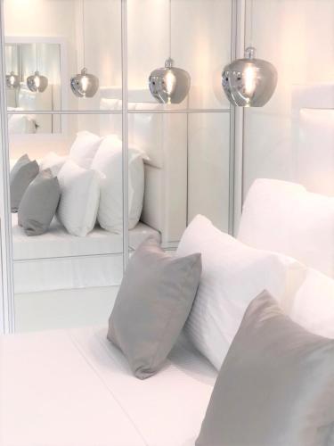 a room with white pillows on a bed with mirrors at Amaryllis Luxury Rooms in Platamonas