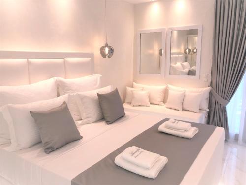 um quarto branco com almofadas brancas numa cama em Amaryllis Luxury Rooms em Platamon