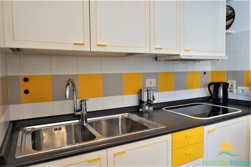 a kitchen with a stainless steel sink and white cabinets at Green relax apartment - Holiday Home Garda Trentino in Riva del Garda