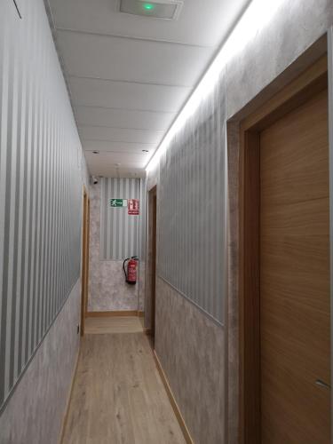 a corridor of a hallway with a door and a room at Hostal Juan Bravo in Segovia