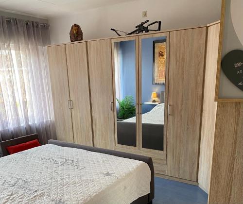 1 dormitorio con cama y espejo grande en Homestay Mimi's Rental, en Brujas