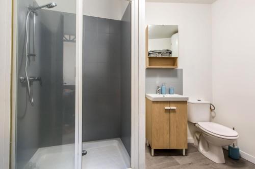 La salle de bains est pourvue d'une douche et de toilettes. dans l'établissement Le ZEN... appartement avec fauteuil massant!, à Tourcoing