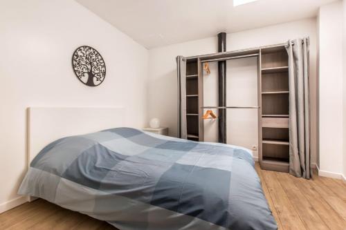 een slaapkamer met een bed en een klok aan de muur bij Le ZEN... appartement avec fauteuil massant! in Tourcoing